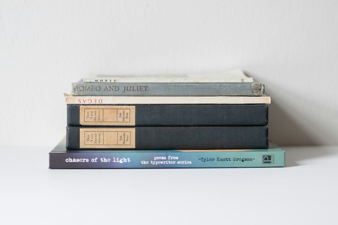 Stack of old books on a wooden desk